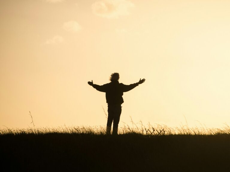 Silhouette of a person with arms spread open at sunrise